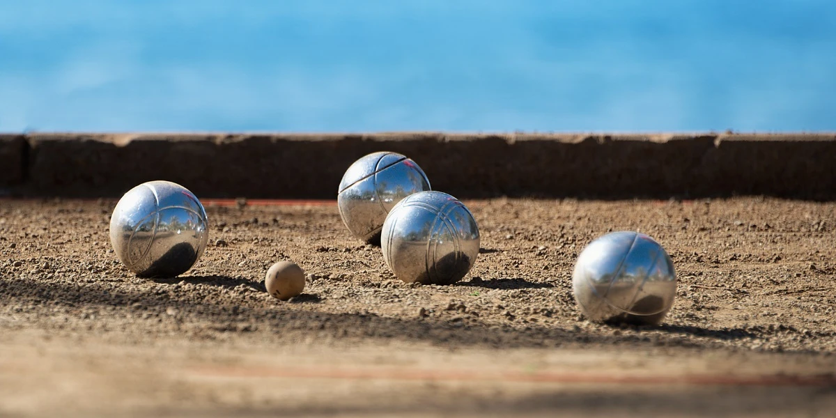 Boules de pétanque sur le terrain, face à la mer